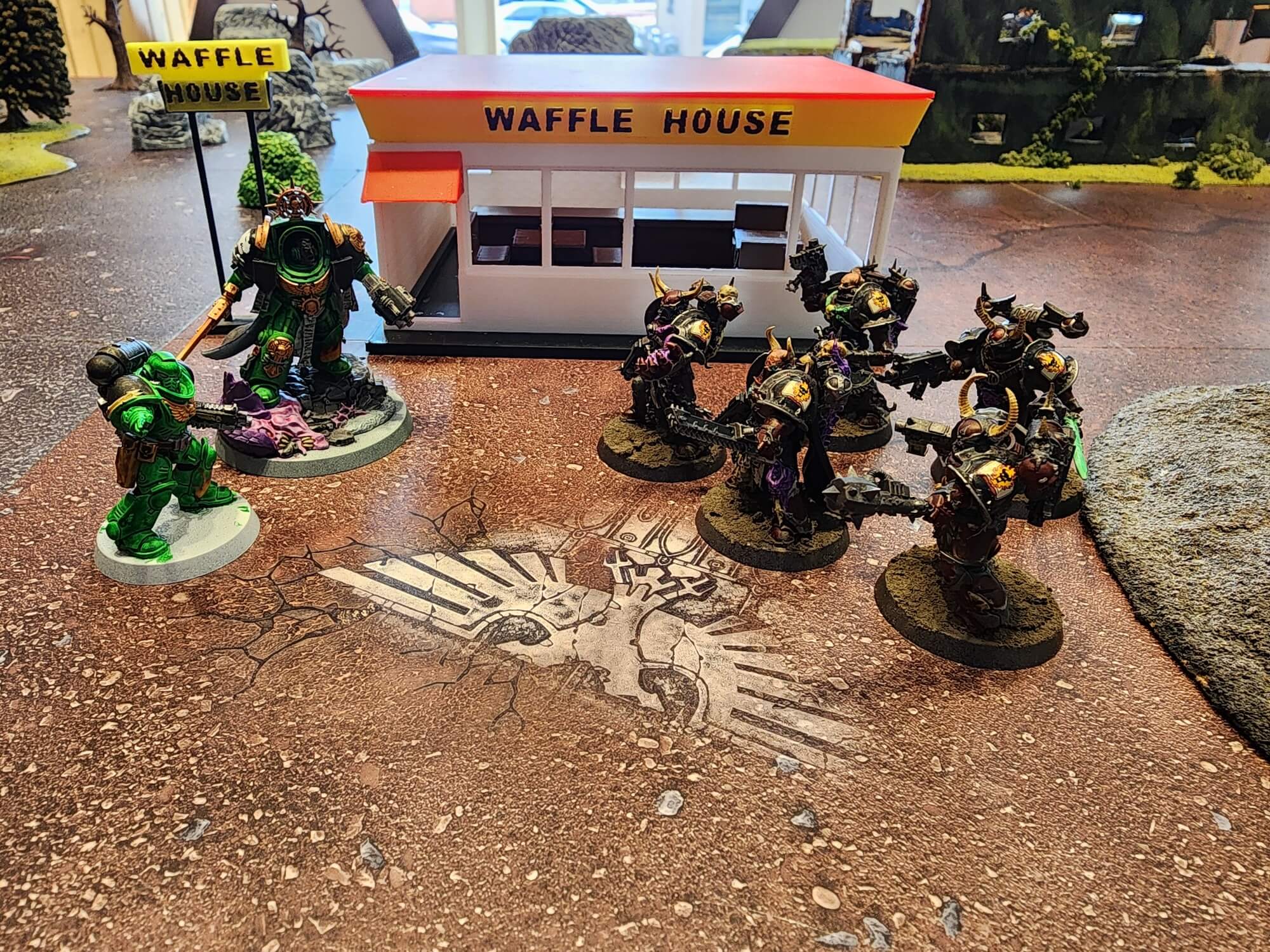 Warhammer miniatures fighting in front of a Waffle House building